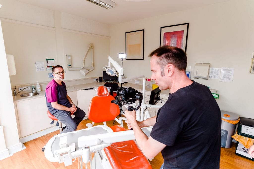 Dentist sitting in the dental surgery being photographed